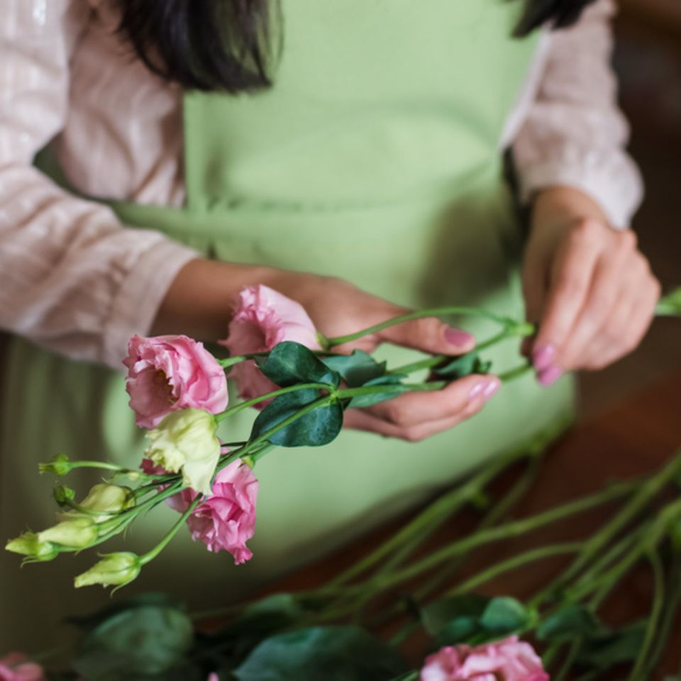 Frau im Geschäft beim Blumen anschneiden