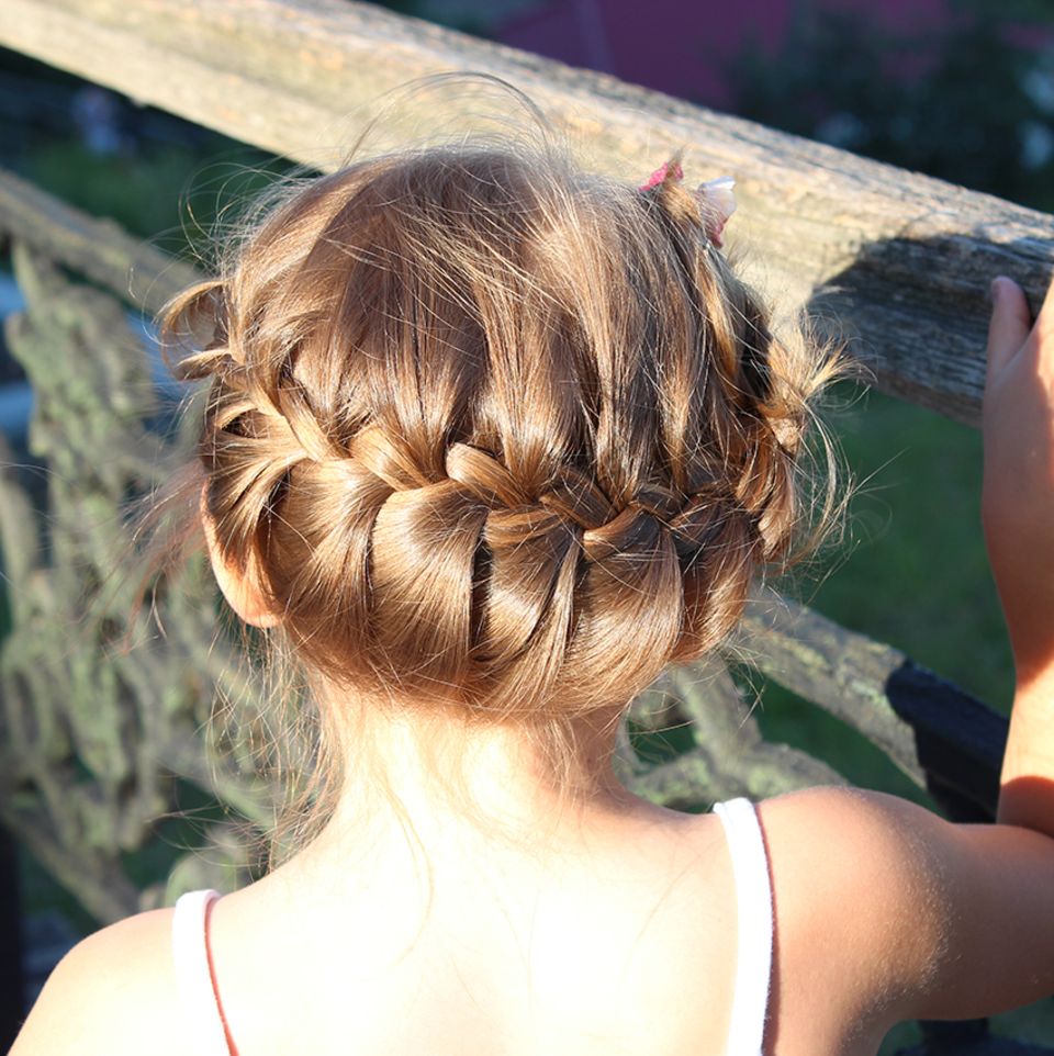 Mädchen mit geflochtener Hochsteckfrisur