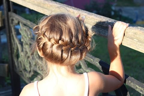 Mädchen mit geflochtener Hochsteckfrisur