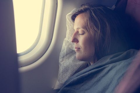 Frau schlafend im Flugzeug
