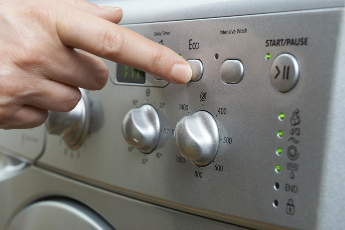 Eco-Knopf an der Waschmaschine wird gedrückt