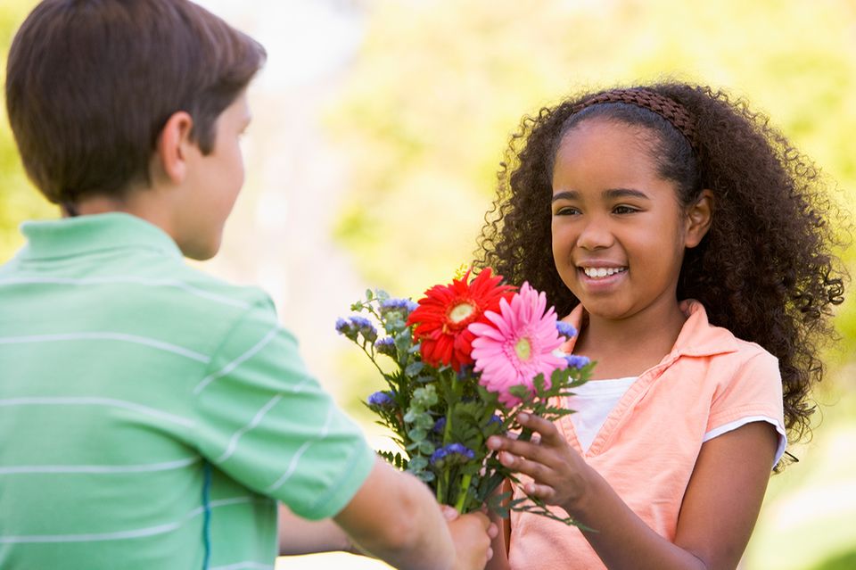 Junge schenkt Mädchen Blumen