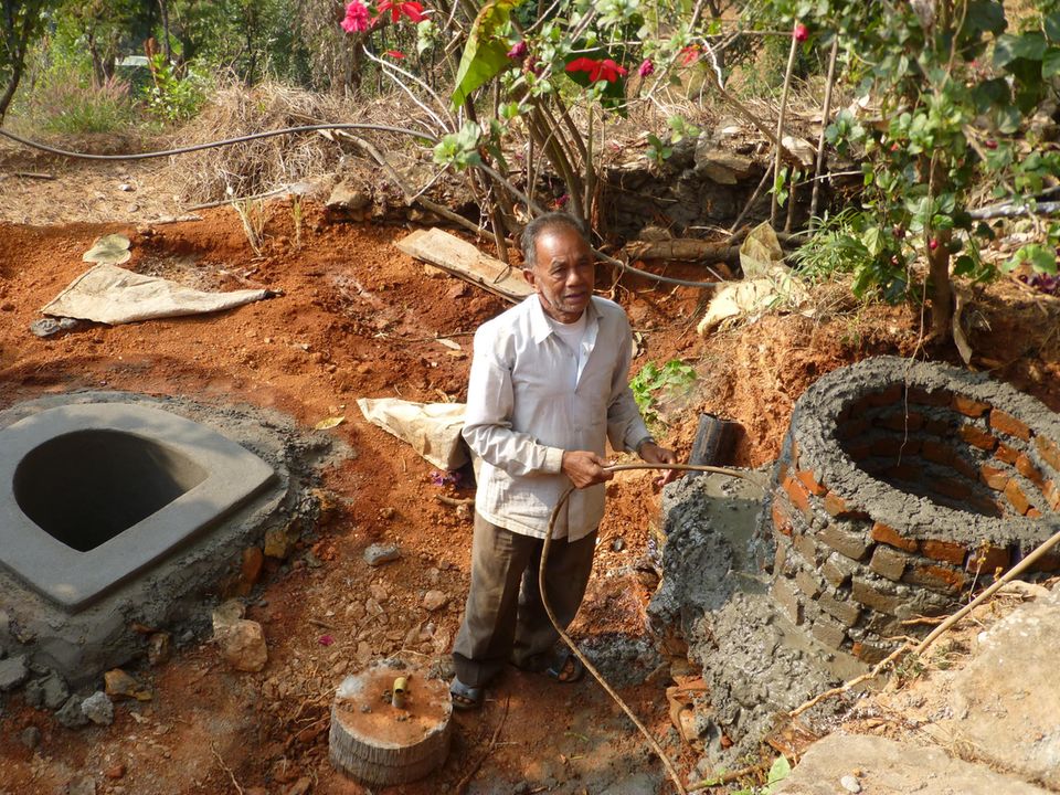 Ein Projektbegünstigter bei der Befeuchtung seiner frisch gebauten Anlage Ein Projektbegünstigter bei der Befeuchtung seiner frisch gebauten Anlage
