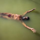 Ein Sadhu, ein heiliger Mann, schwebt im Wasser des Shipra und führt dabei  Plavini Pranayama aus, eine Atemübung