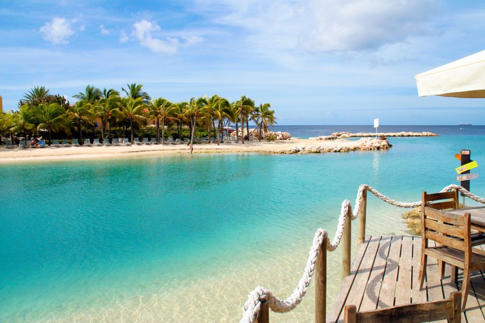 Reisetipps: Blick auf Mambo Beach: Der weiße Sandstrand mit den Kokospalmen gehört zu den bekanntesten Stränden der Karibikinsel Curacao Reisetipps: Blick auf Mambo Beach: Der weiße Sandstrand mit den Kokospalmen gehört zu den bekanntesten Stränden der Karibikinsel Curacao