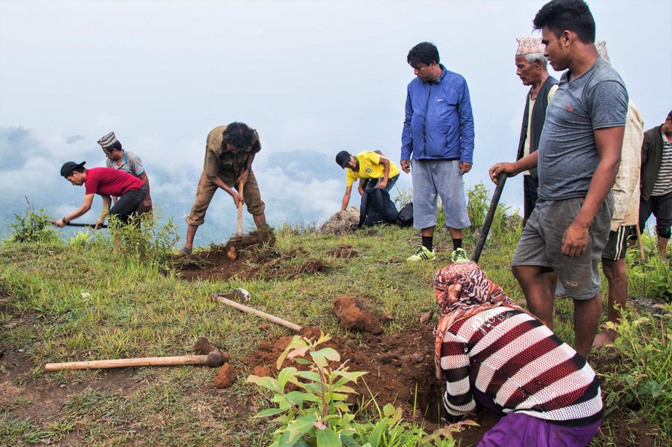 Das Ausheben der Pflanzlöcher unter Aufsicht von Nath Lamsal (blaue Jacke), Experte der Forstbehörde des Distrikts Dhading