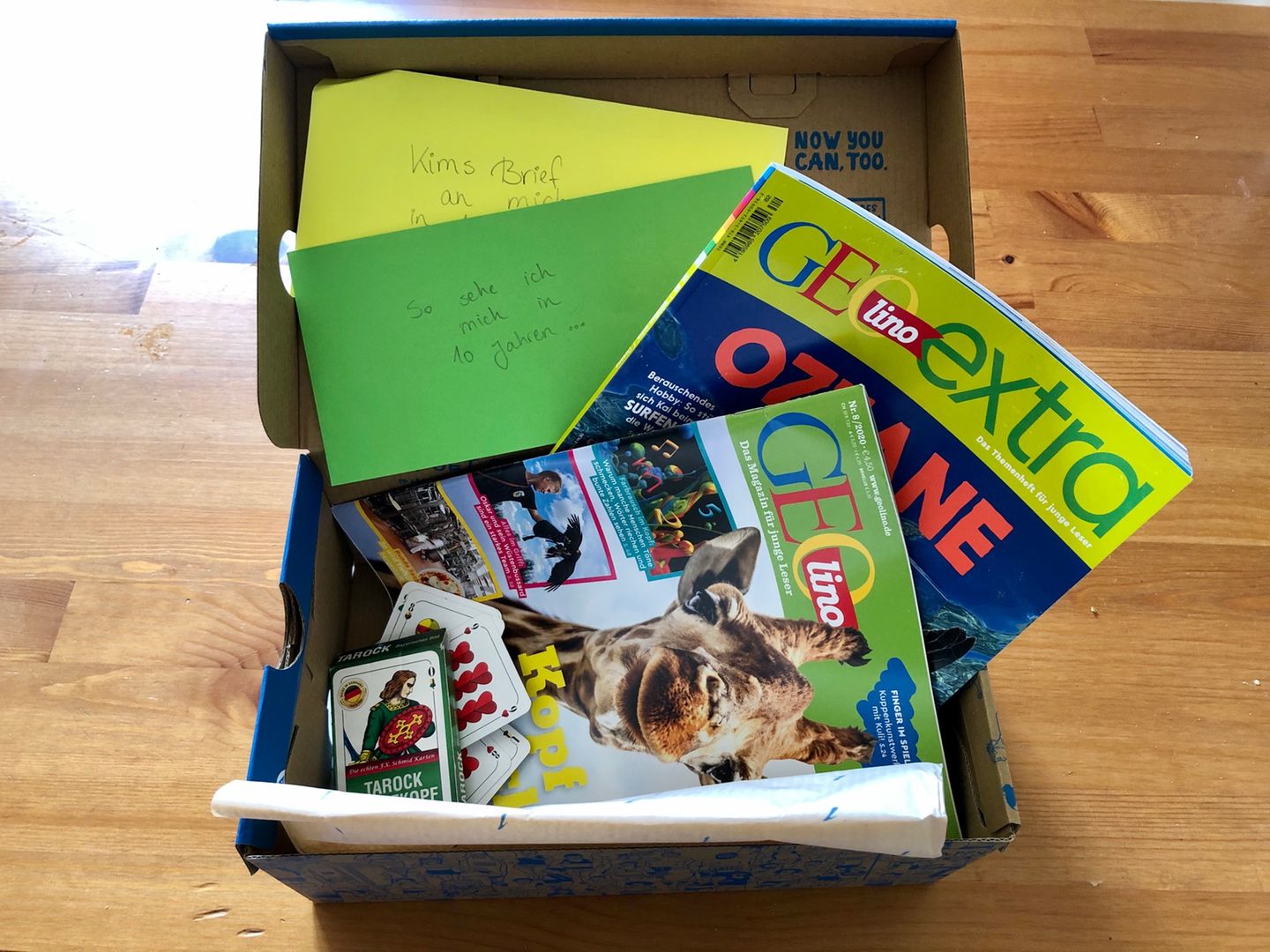 Briefe, Magazine und ein Spiel in einer Kiste