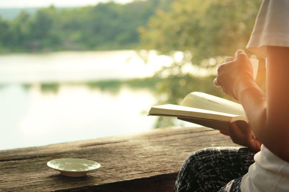 Frau trinkt Kaffee am See