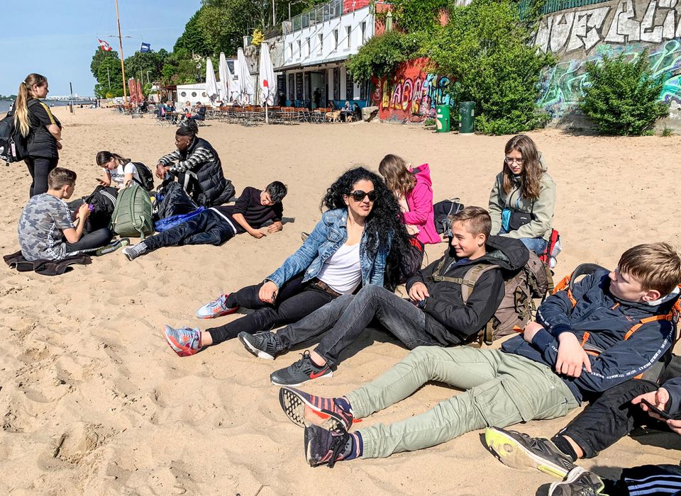 Geschafft! Am Ende der Reise entspannt die Klasse am Hamburger Elbstrand in der Sonne Geschafft! Am Ende der Reise entspannt die Klasse am Hamburger Elbstrand in der Sonne