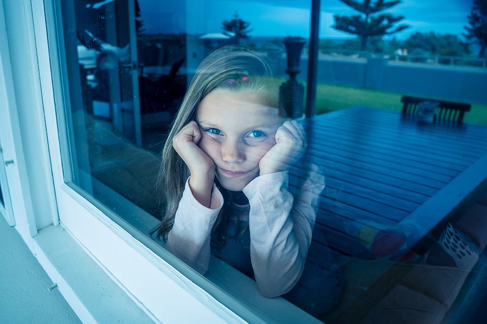 Mädchen isoliert hinter der Fensterscheibe