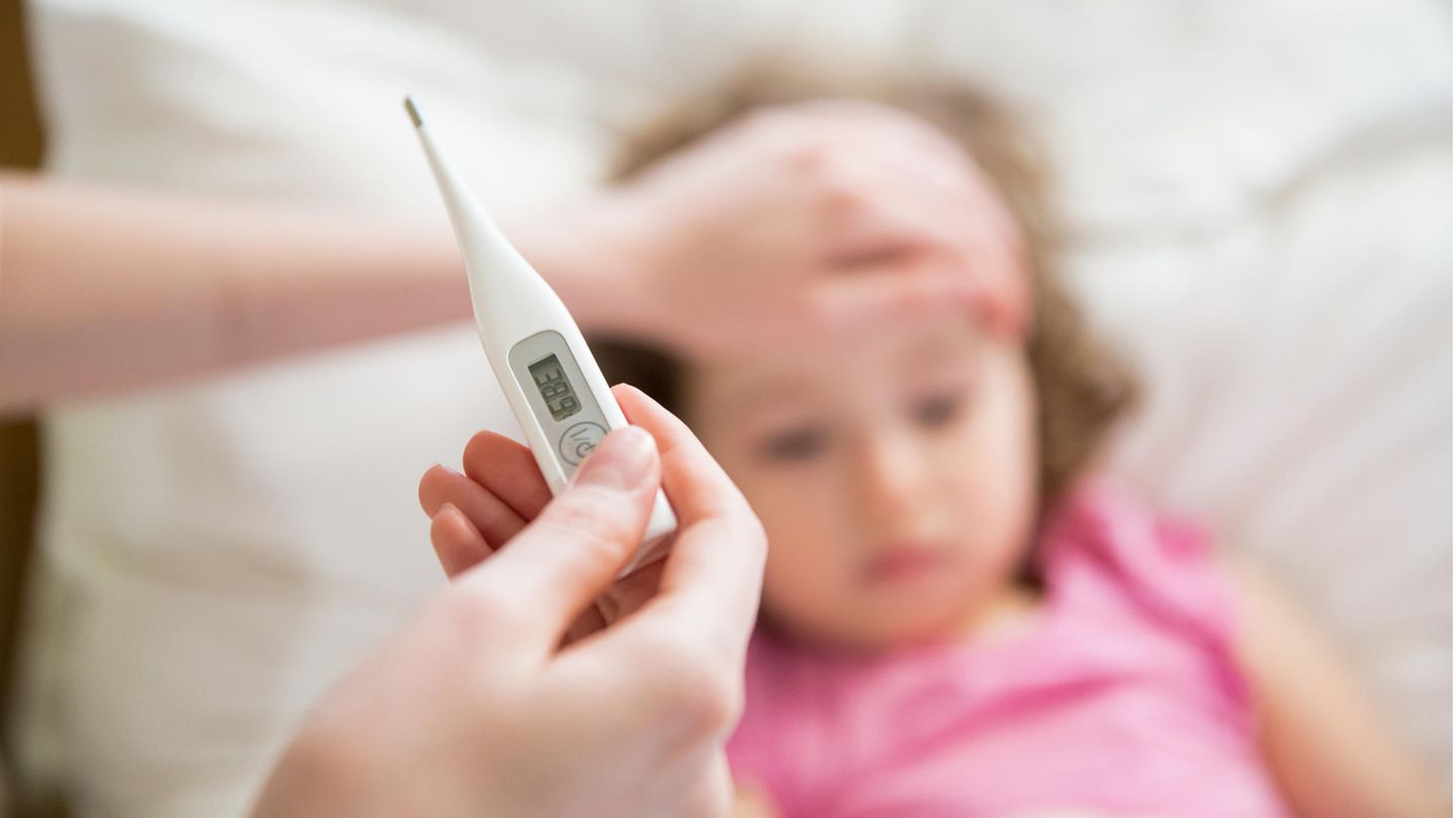 Mutter misst die Temperatur ihrer kranken Tochter