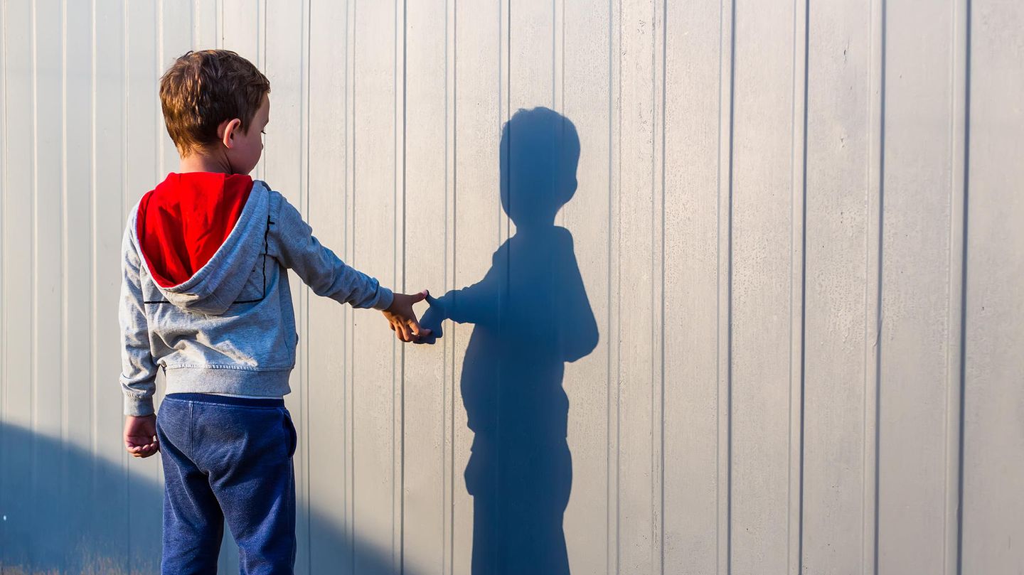 Ein Junge berührt seinen Schatten