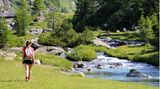 Wandernde Frau am Fluss in den Alpen