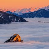 Dieses Bild entstand an einem klaren Novemberabend auf der Hochplatte. Gerade eben noch sticht die Spitze des Leonhardsteins aus dem Hochnebel hervor, dahinter glühen die zackigen Gipfel des Wilden Kaisers und der Loferer Steinberge.