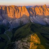 Die Szenerie erinnert an Patagonien. Markante Felsklippen strahlen golden im Abendlicht, tief unten liegen die eingeschnittenen Täler bereits im Dunkeln