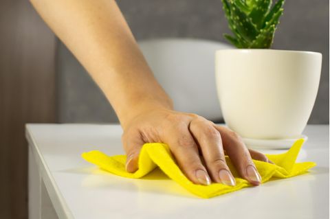 Frau putzt einen Tisch ab