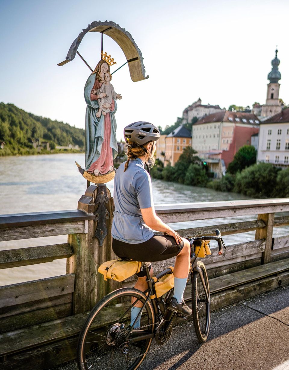 Die Salzach in Burghausen markiert die Grenze zwischen Österreich und Deutschland. Auf der Brücke gibt’s Beistand von oben. Rechts: Parkplatz mit Wirtschaftsanschluss in Amerang bei Wasserburg