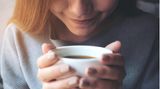 Junge Frau genießt den Geruch ihres Kaffees