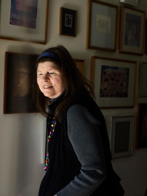 Lonni Sue vor einer Wand mit ihren Gemälden