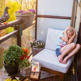 Mädchen erschreckt sich vor Taube auf dem Balkon