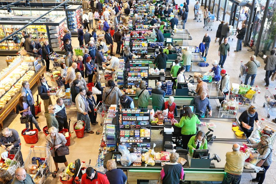 Wartende Menschen an der Supermarktkasse