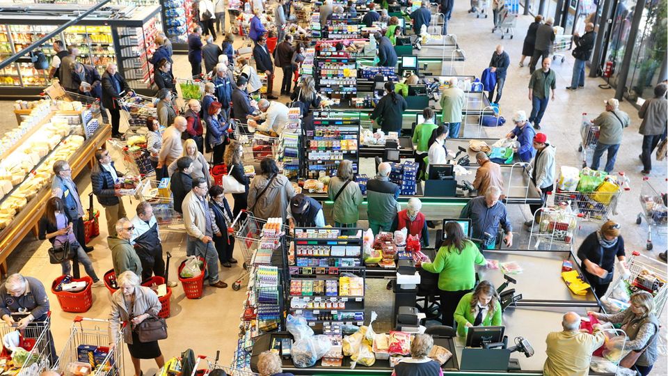 Wartende Menschen an der Supermarktkasse Wartende Menschen an der Supermarktkasse