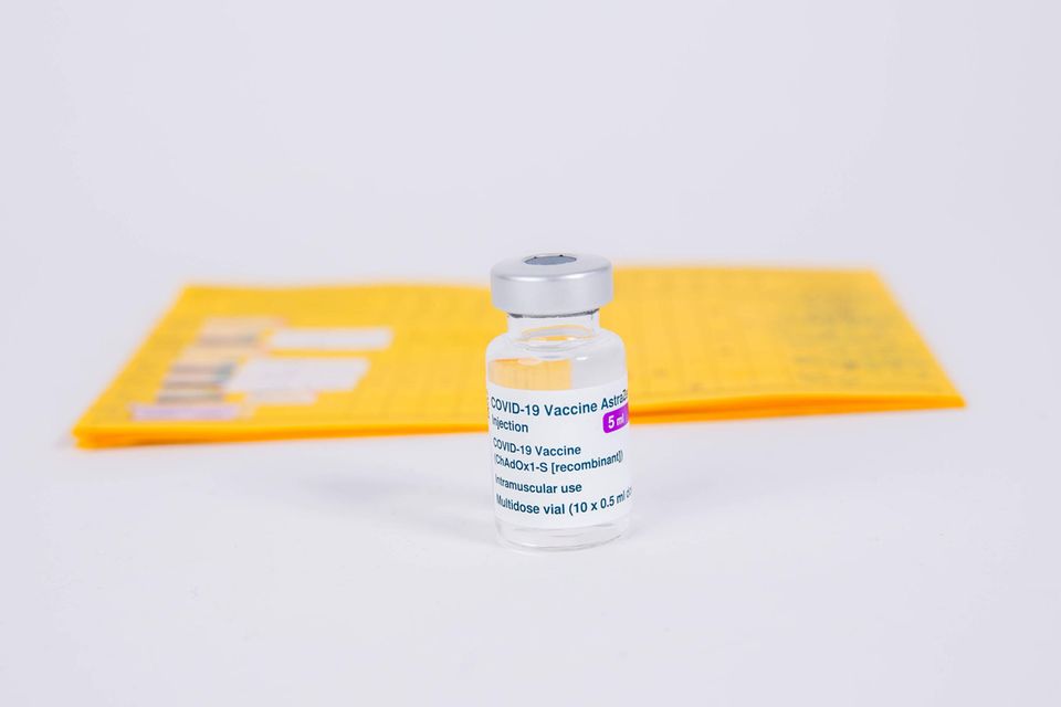 Impfampulle steht vor einem Impfpass