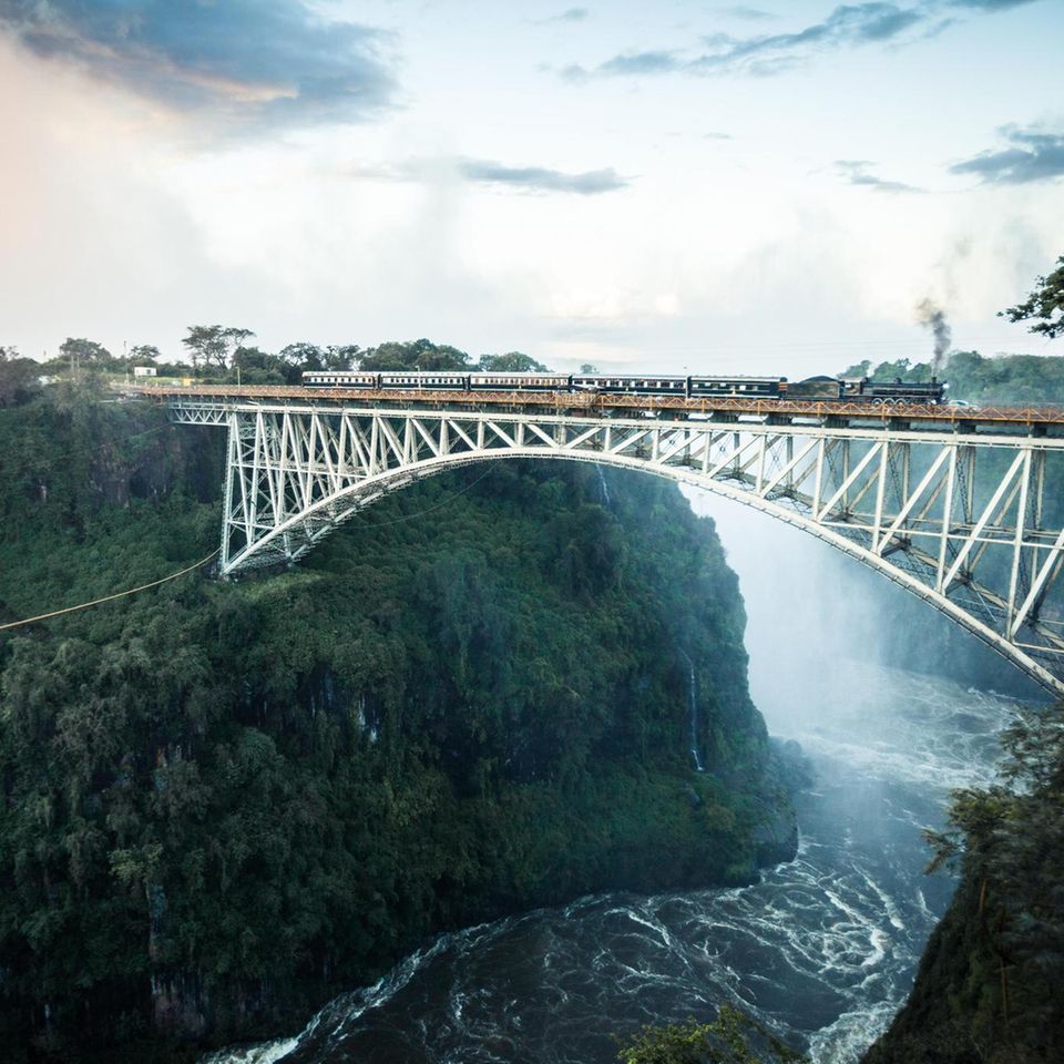1855 taufte der Entdecker David Livingstone den Wasserfall des Sambesi zu Ehren seiner Königin "Victoria Falls". Die Ein­hei­mischen nennen ihn Mosi oa Tunya, "donnern­der Rauch", wegen der mitunter mehr als 300 Meter hohen Gischtwolke