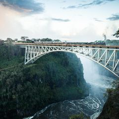 1855 taufte der Entdecker David Livingstone den Wasserfall des Sambesi zu Ehren seiner Königin "Victoria Falls". Die Ein­hei­mischen nennen ihn Mosi oa Tunya, "donnern­der Rauch", wegen der mitunter mehr als 300 Meter hohen Gischtwolke