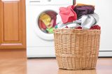 Wäschekorb steht vor einer Waschmaschine