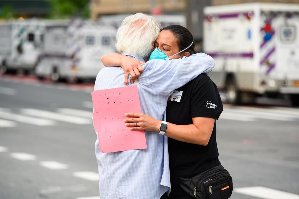 NEW YORK, NEW YORK - MAY 29: A medical worker hugs a COVID-19 survivor outside NYU Langone Health hospital during the coronavirus pandemic on May 29, 2020 in New York City. Government guidelines encourage wearing a mask in public with strong social dist...