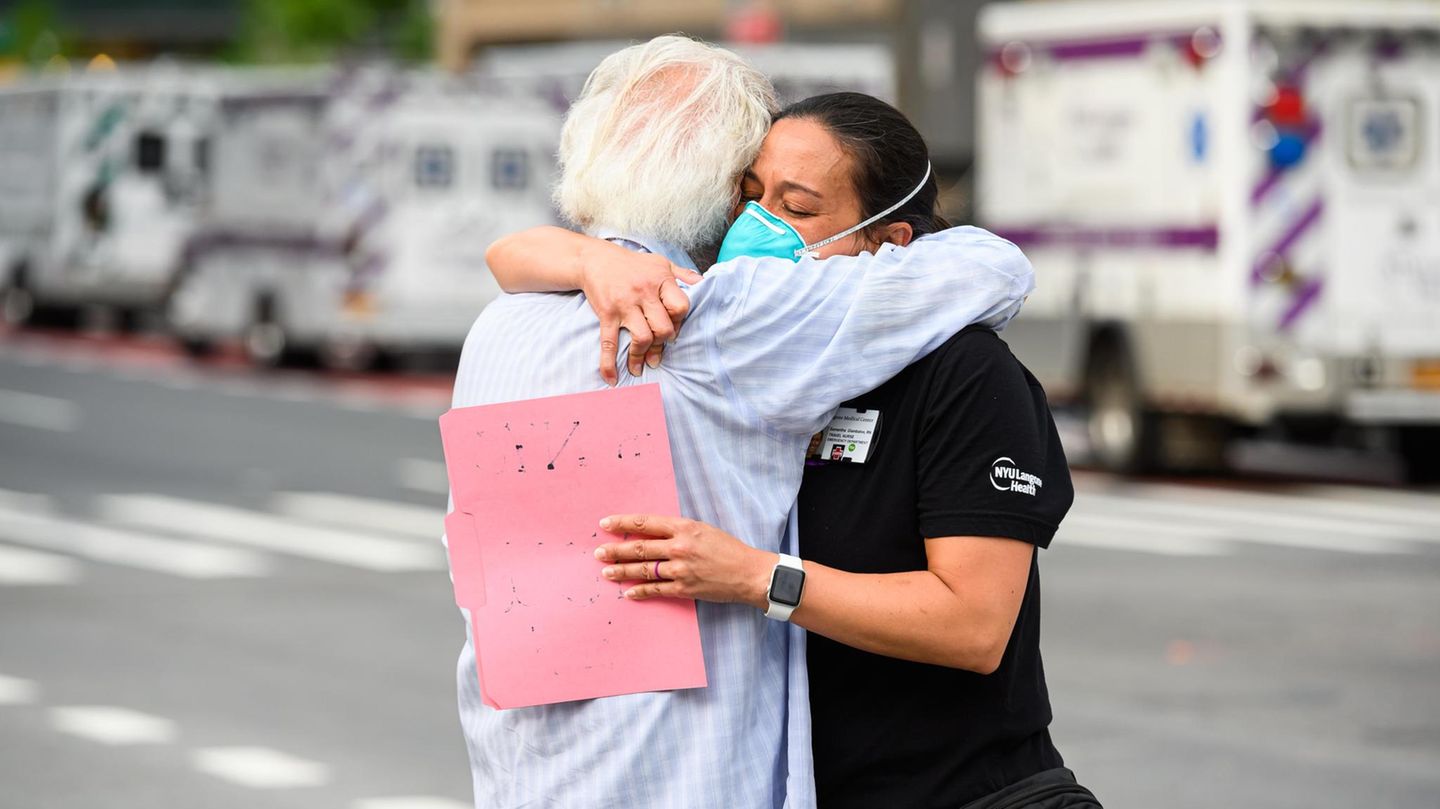 NEW YORK, NEW YORK - MAY 29: A medical worker hugs a COVID-19 survivor outside NYU Langone Health hospital during the coronavirus pandemic on May 29, 2020 in New York City. Government guidelines encourage wearing a mask in public with strong social dist...