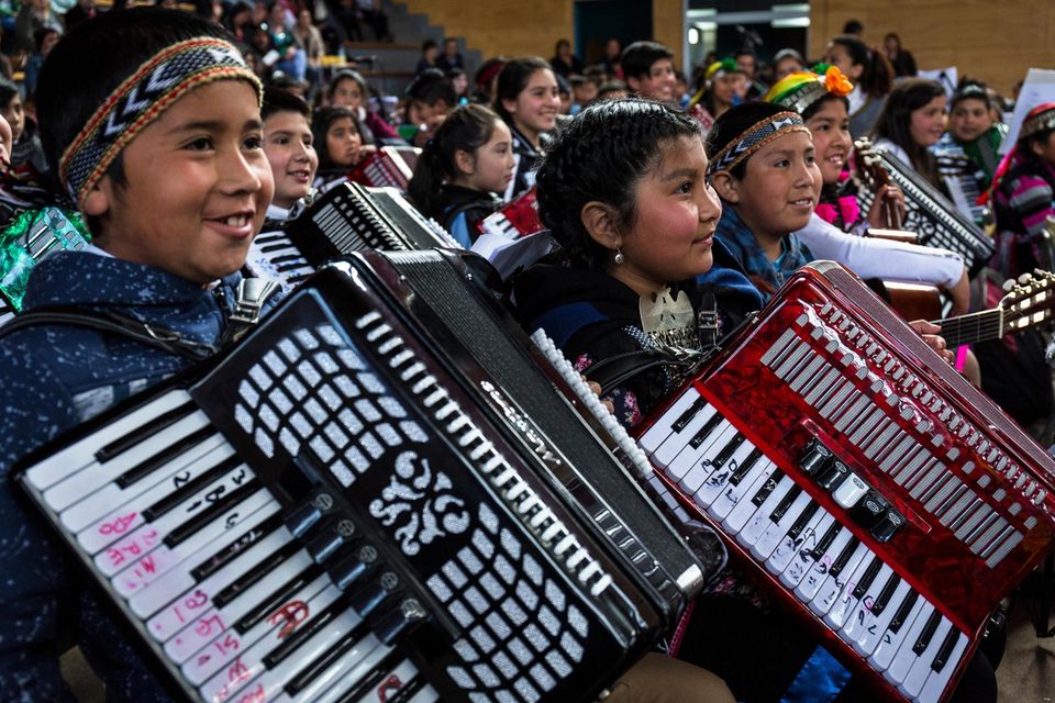 The annual music concert given by the one thousand one hundred and twenty children who participate in the Papageno music school programme of music education given to rural primary school kids in the Araucanía region of Chile. Seen here a group of native...