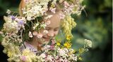 Glückliches Mädchen mit einem Blumenkranz