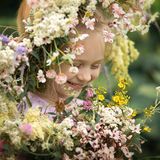 Glückliches Mädchen mit einem Blumenkranz