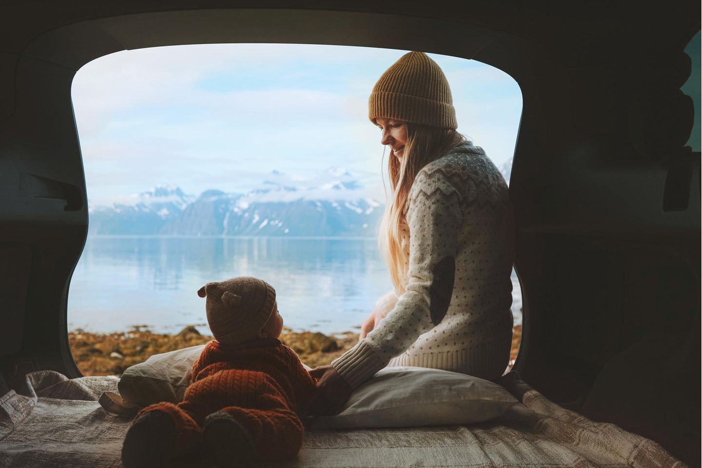 Einen Camper leihen und draußen übernachten Junge Mutter und Baby im Camper