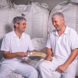 Zwei Männer sitzen mit Zutaten für die Wiener Würze zusammen