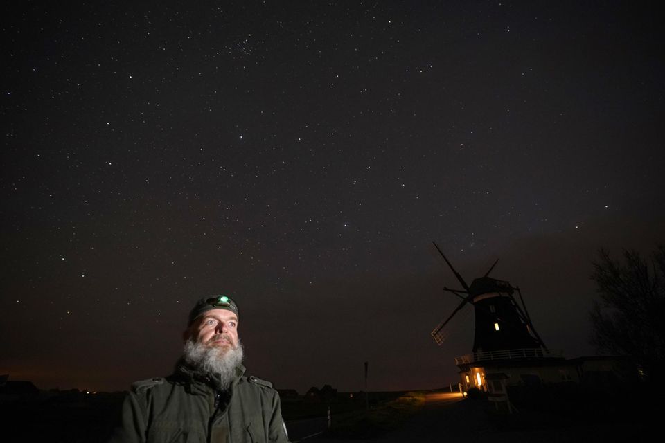 Sternenhimmel: Oliver Jedath von der Projektgruppe Sterneninsel Pellworm steht in der Nacht mit einer Stirnlampe an der Nordermühle auf der Insel Pellworm Oliver Jedath von der Projektgruppe Sterneninsel Pellworm steht in der Nacht mit einer Stirnlampe an der Nordermühle auf der Insel Pellworm