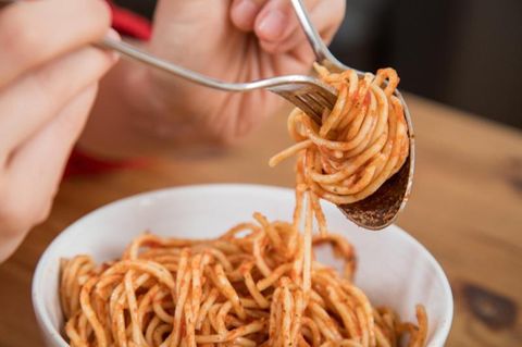 Spaghetti werden auf eine Gabel gerollt