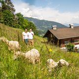 Schafe und Matthias und Theresa Kollnig vor dem Hof