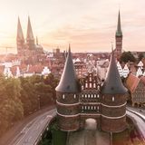 Backsteingotik und natürlich Marzipan. Das fällt mir als Erstes ein, wenn ich an meine Geburtsstadt denke, die Heimat meiner Eltern und Großeltern, in der noch heute viele Verwandte wohnen. Meine ersten Kindheitsjahre habe ich südwestlich der von der Trave umspülten Altstadtinsel verbracht. Seit 1987 steht sie auf der Welterbeliste der UNESCO. Ihre mittelalterliche Silhouette mit den mächtigen Kirch- und Tortürmen ist einzigartig – und kündet vom Stolz der Hansekaufleute, die von hier aus einst Geschäfte mit dem gesamten Ost- und Nordseeraum machten. Kurzum: Backstein heißt für mich Heimat. Und so wohne ich auch in Hamburg hinter historischen Fassaden: rotem Klinker aus den 1920er-Jahren.  Mein Tipp: Statt des berühmten Niederegger Marzipans mal das von Mest probieren – nicht wenige Einheimische schwören darauf. Ladengeschäft auf der Altstadtinsel, mest.de  Anja Fries, Textredakteurin