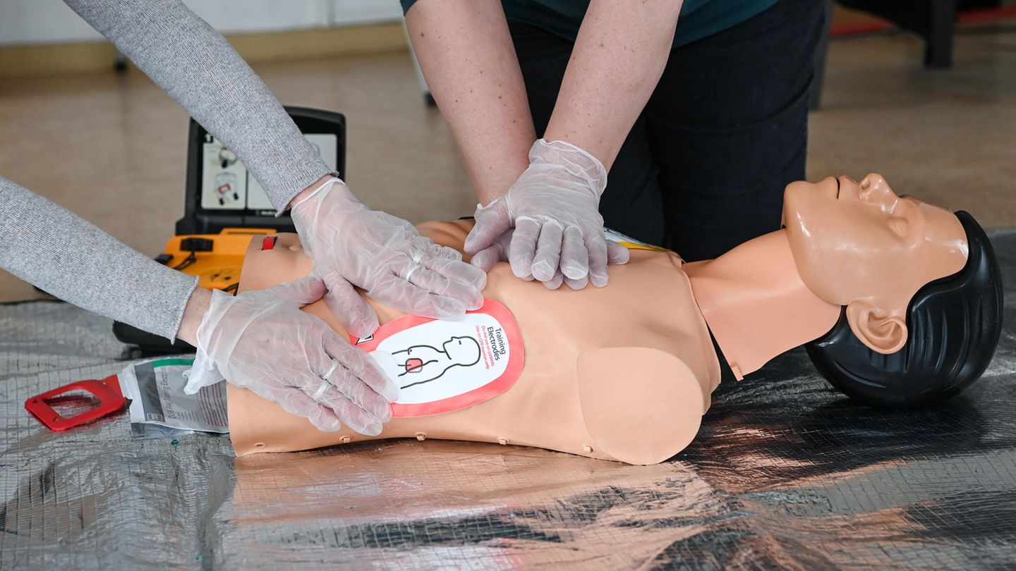 Ausbilderinnen vom Arbeiter-Samariter-Bund (ASB) demonstrieren an einer Reanimationspuppe in einem Ersthelferkurs die Wiederbelebung mit Einsatz eines Defibrillators