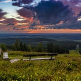 Blick vom Erbenskopf – zwei Bänken stehen in der grünen Landschaft