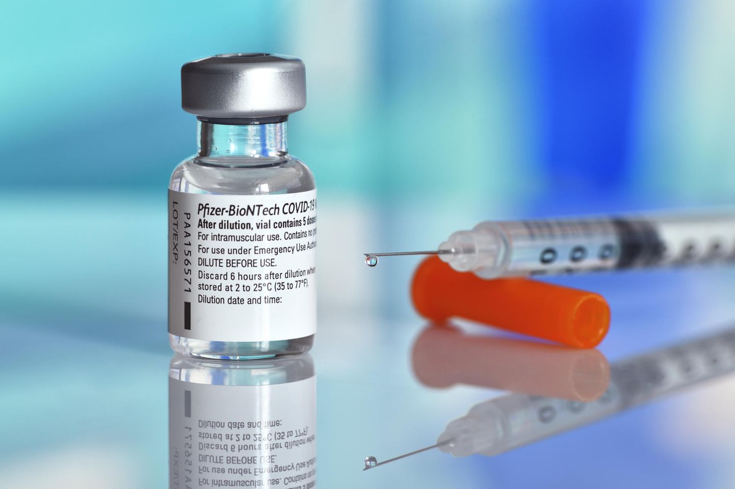 Biontech-Impfstoff mit Spritze im Hintergrund