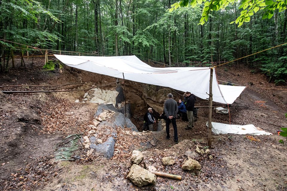 Archäologen stehen unter einer Plane bei den Ausgrabungen an der Einhornhöhle Archäologen stehen unter einer Plane bei den Ausgrabungen an der Einhornhöhle