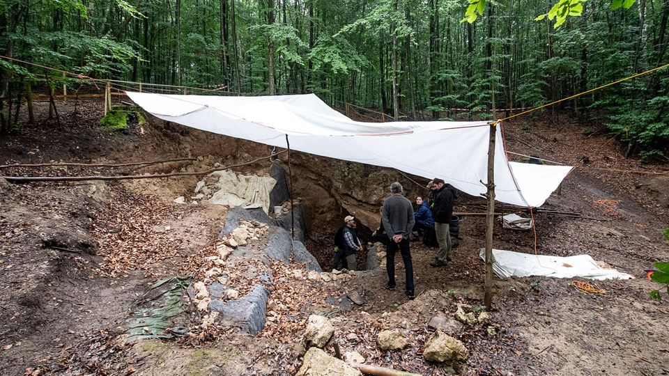 Archäologen stehen unter einer Plane bei den Ausgrabungen an der Einhornhöhle Archäologen stehen unter einer Plane bei den Ausgrabungen an der Einhornhöhle