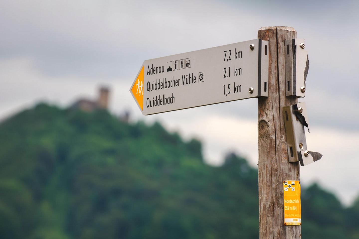 Schild im Vordergrung und im Hintergrund die Nürburg