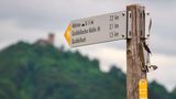 Schild im Vordergrung und im Hintergrund die Nürburg