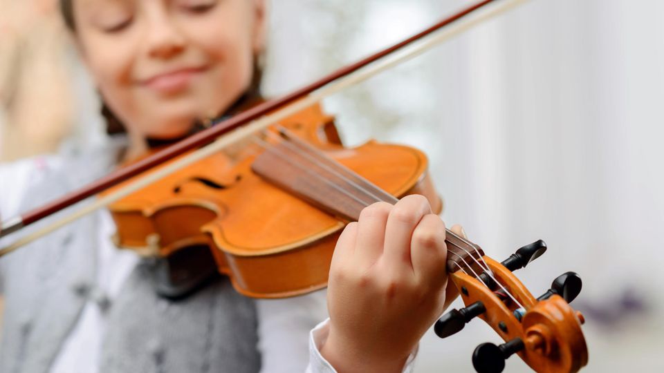 Eine junge Frau spielt lächelnd Geige