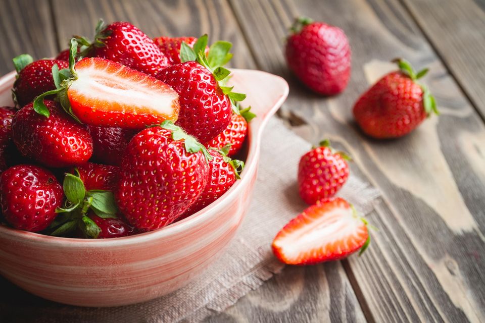 Frische Erdbeeren in einer Schüssel auf einem Holztisch